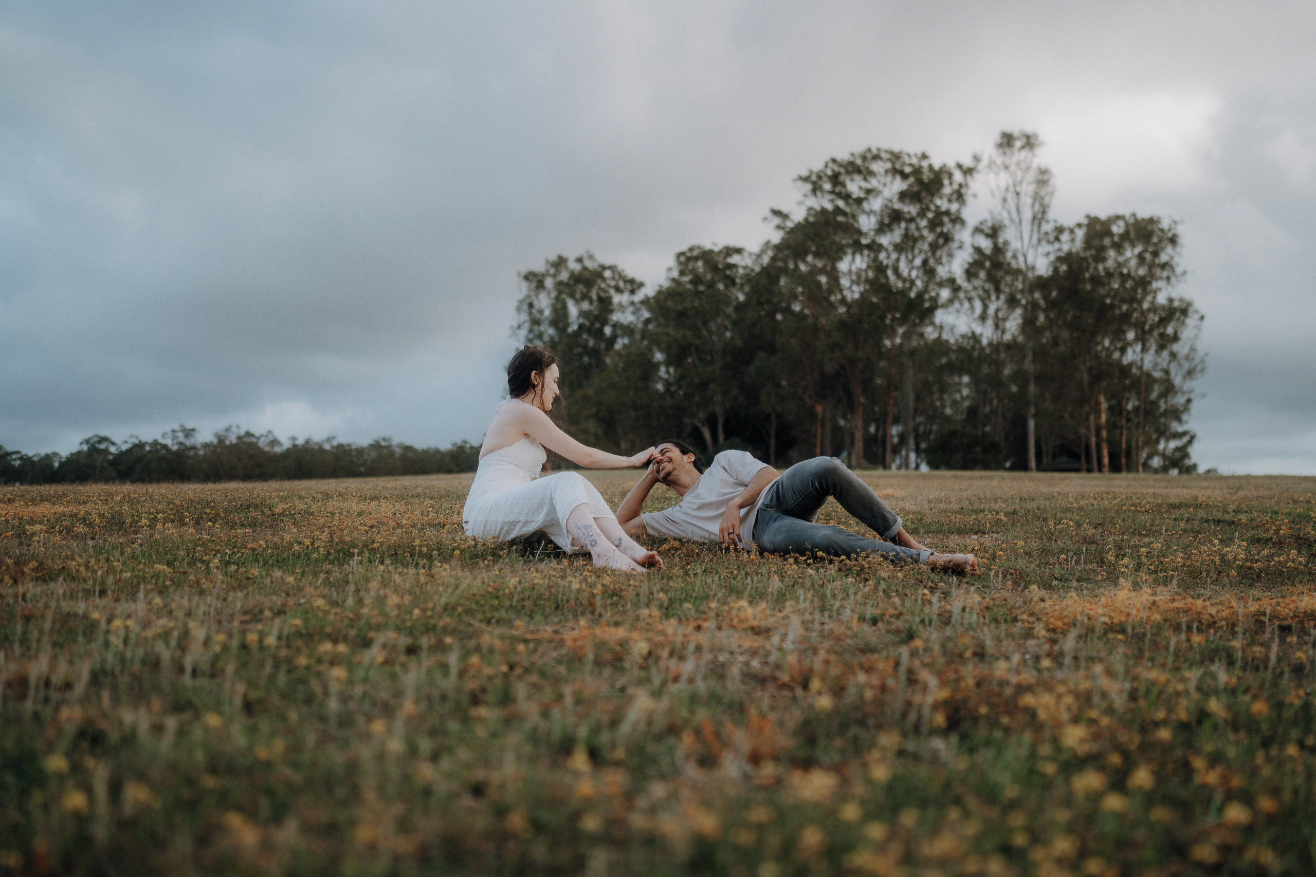 A man and woman sitting in a field.